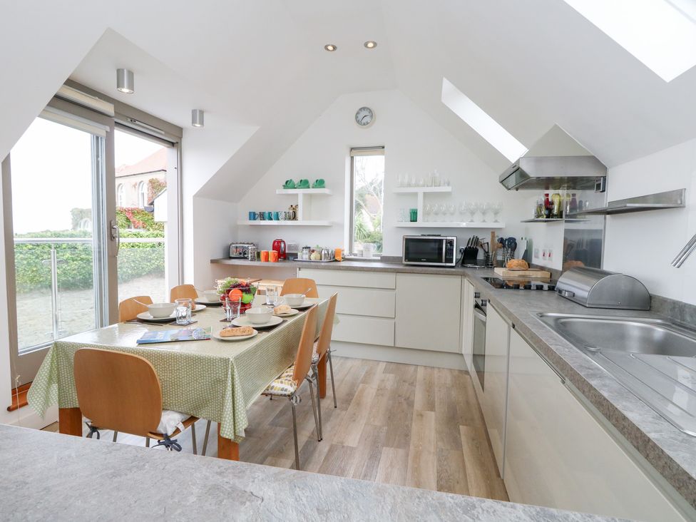 A kitchen with dining table and chairs at Coastguard Lookout in Wyke Regis