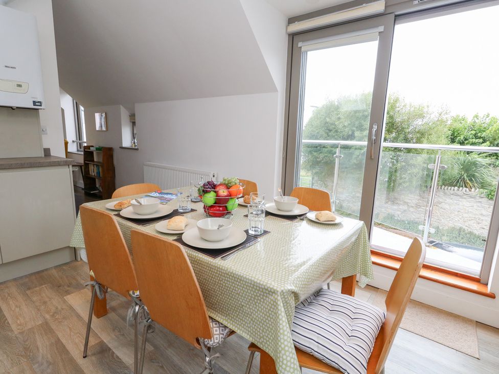 A dining room with a table set for meals at Coastguard Lookout in Wyke Regis