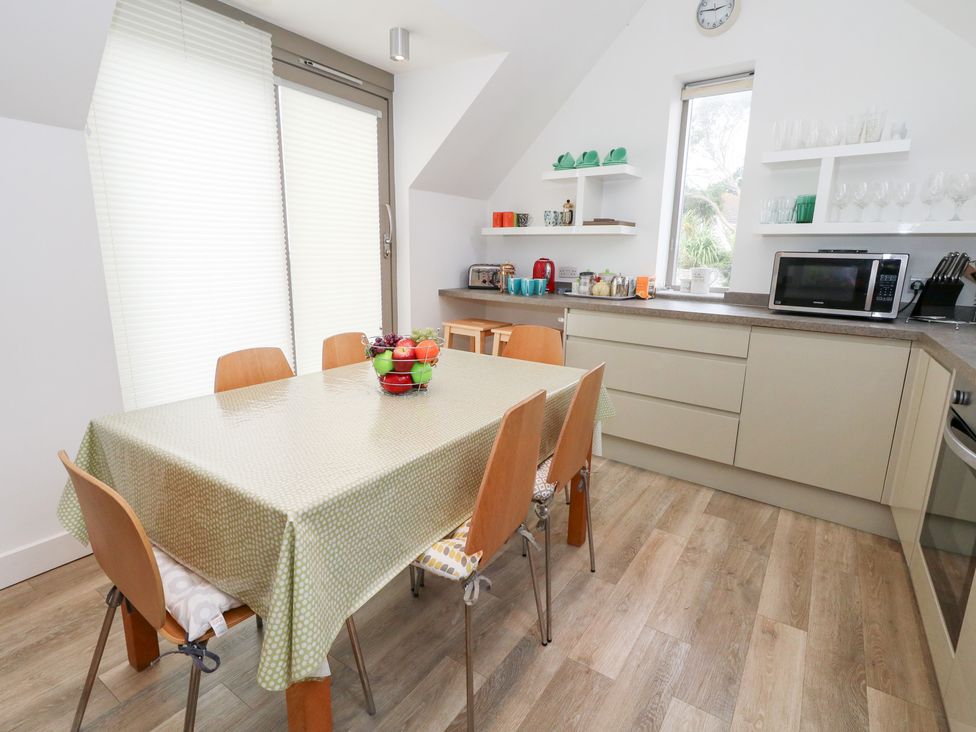 A kitchen with a dining table and chairs at Coastguard Lookout in Wyke Regis
