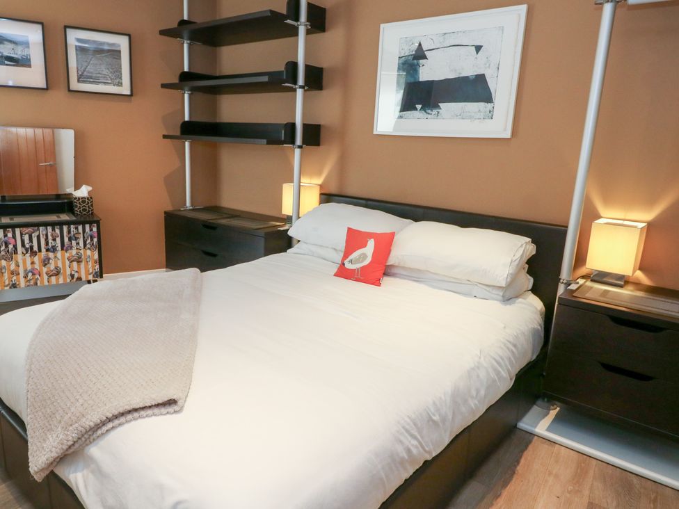 A bedroom with a bed and nightstands at Coastguard Lookout in Wyke Regis