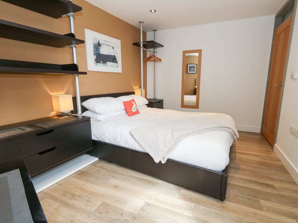 A bedroom with a bed and shelves at Coastguard Lookout in Wyke Regis