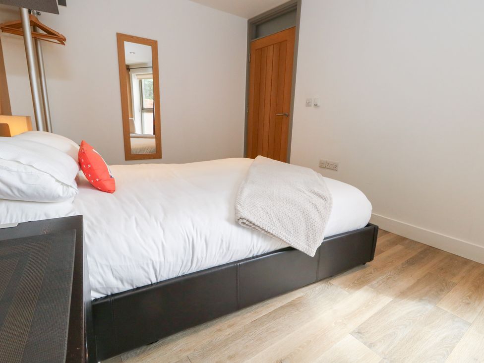 A bedroom with a bed and mirror at Coastguard Lookout in Wyke Regis