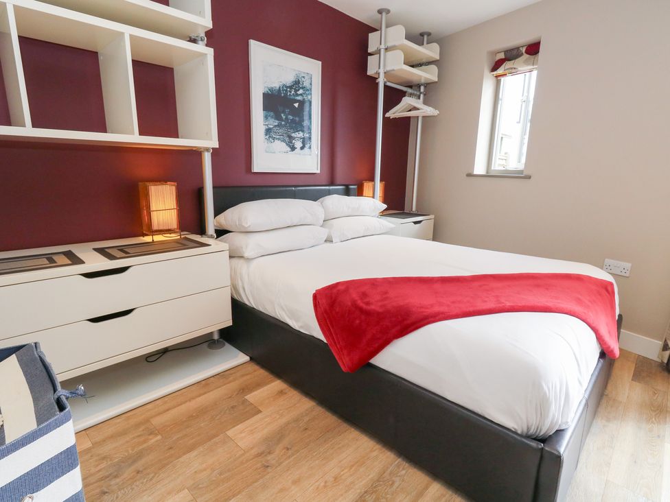 A bedroom with a bed and shelf at Coastguard Lookout in Wyke Regis