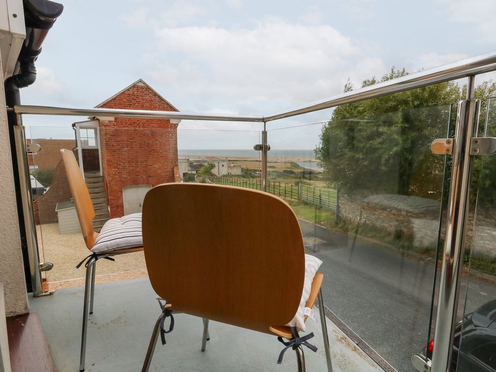 A balcony with two chairs and a view at Coastguard Lookout in Wyke Regis