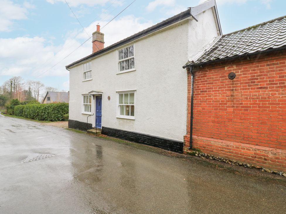 A house with a blue door and brick wall at White Gates in Banham