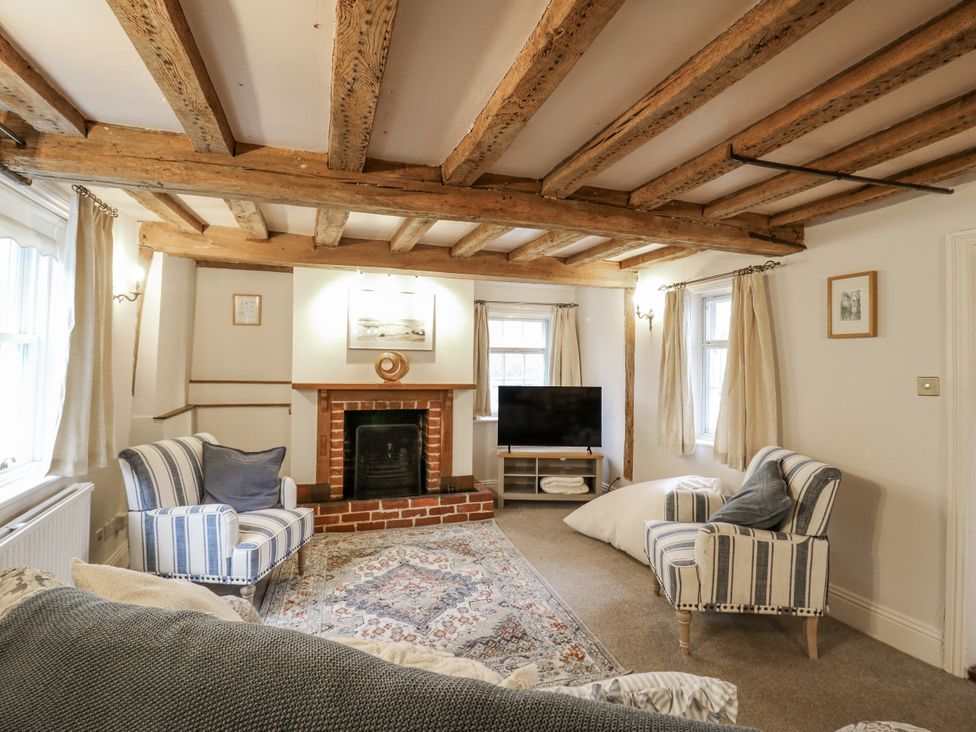 A living room with a fireplace and sofa at White Gates in Banham