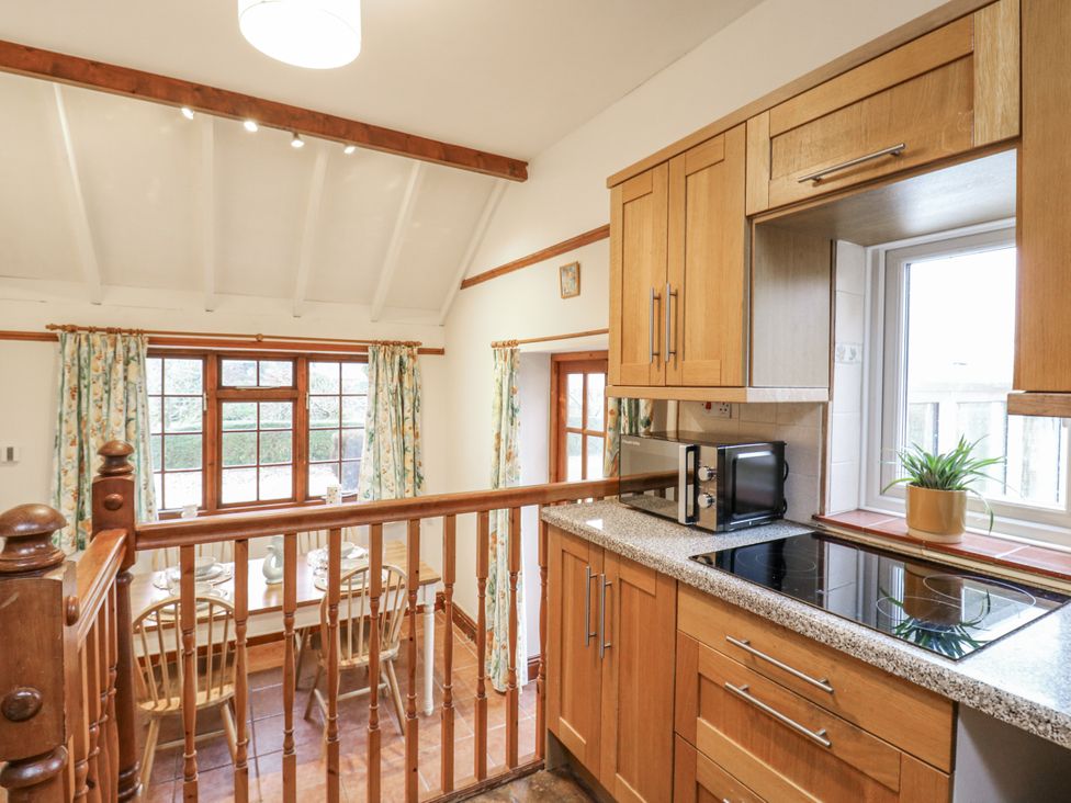 A kitchen with cabinets and a dining table at White Gates in Banham