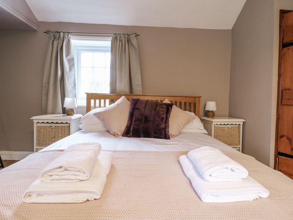 A bedroom with a bed and bedside tables at White Gates in Banham