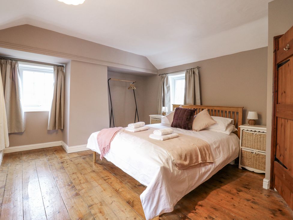 A bedroom with a bed and wardrobe at White Gates in Banham