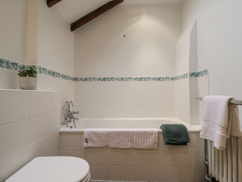 A bathroom with a bath tub and a toilet at White Gates in Banham