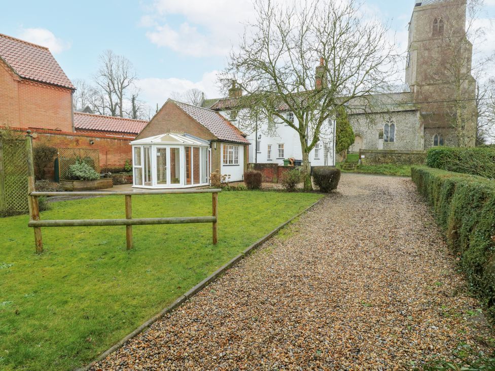 A garden with a conservatory and gravel path at White Gates in Banham