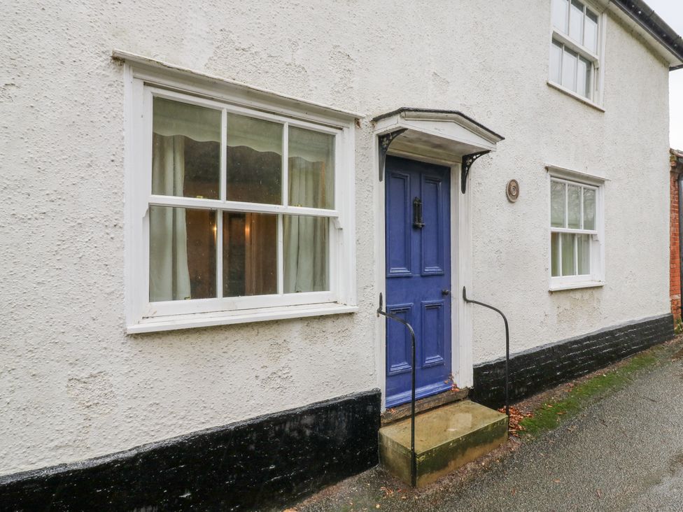 A house exterior with a blue door and windows at White Gates in Banham