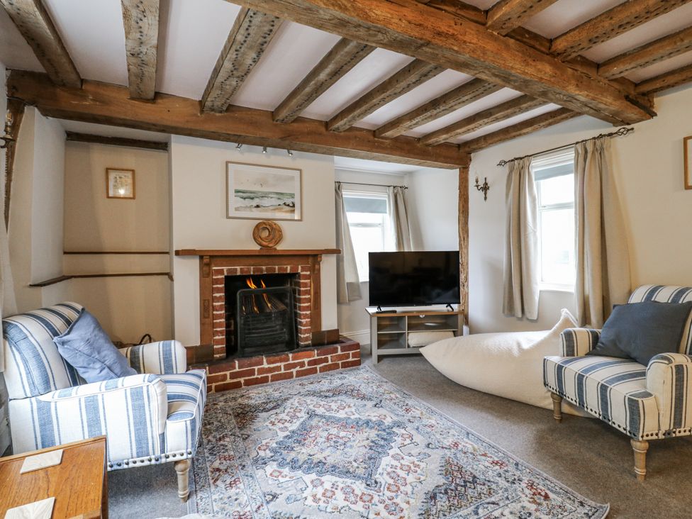 A living room with a fireplace and television at White Gates in Banham
