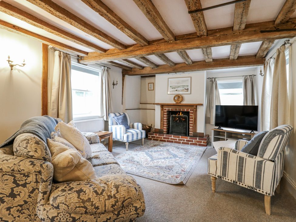 A living room with a sofa and fireplace at White Gates in Banham