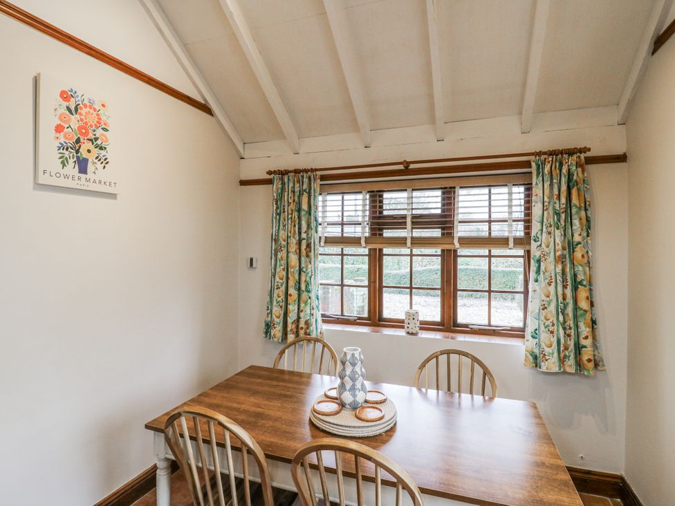 A dining room with a wooden table and chairs at White Gates in Banham