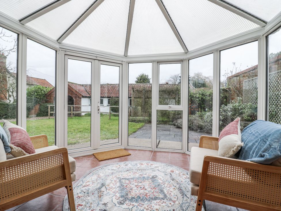 A conservatory with seating and a view of the garden at White Gates in Banham