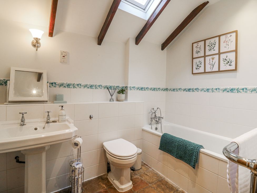 A bathroom with a bathtub, sink, and toilet at White Gates in Banham