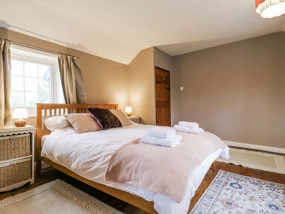 A bedroom with a bed and nightstand at White Gates in Banham