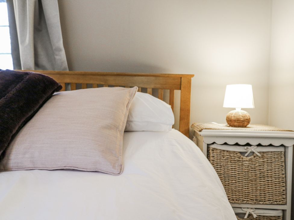 A bedroom with a bed and lamp at White Gates in Banham