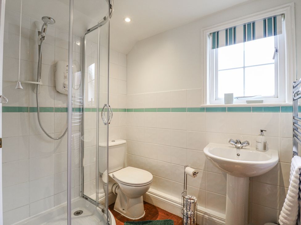 A bathroom featuring a shower, toilet, and sink at White Gates in Banham