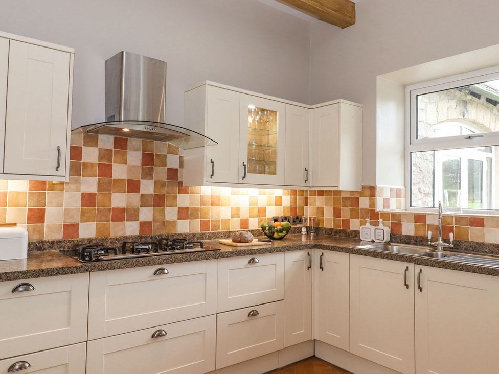 A kitchen with cabinets and a sink at The Gatehouse in 