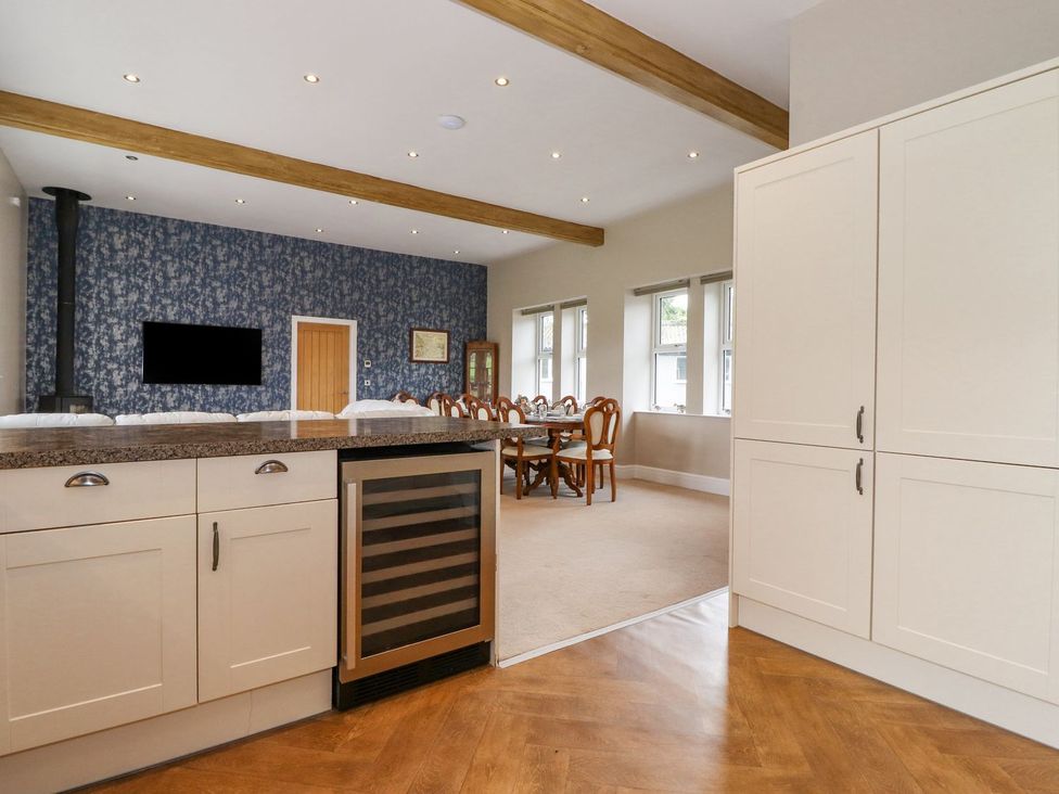 A kitchen with cabinets and a dining area at The Gatehouse 