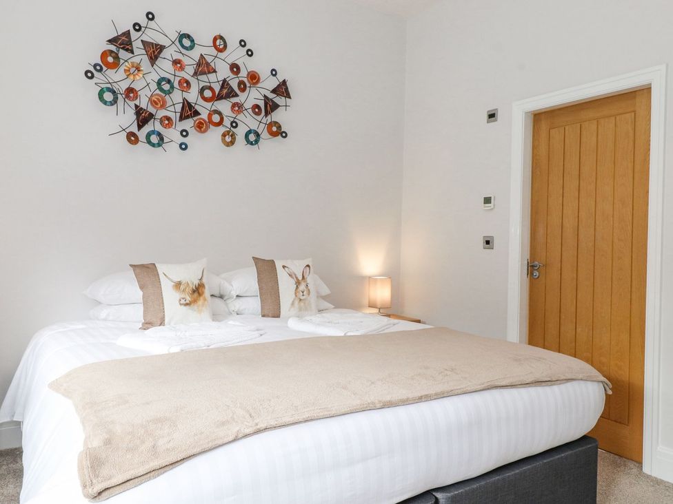 A bedroom with a double bed and decorative wall art at The Gatehouse in 