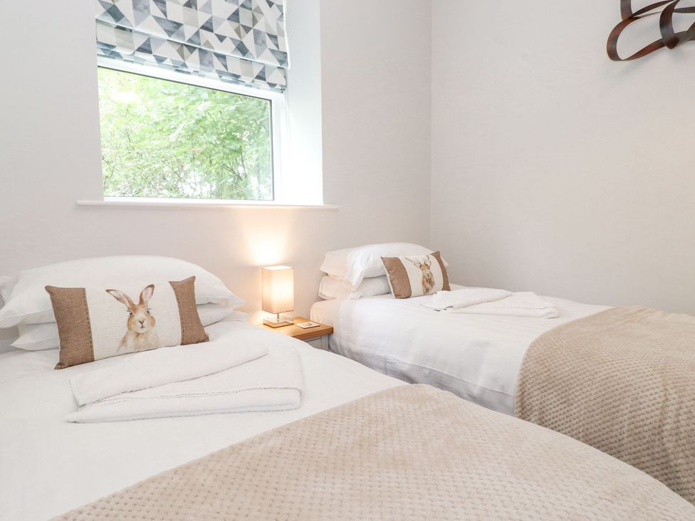 A bedroom with two beds and a lamp at The Gatehouse in 