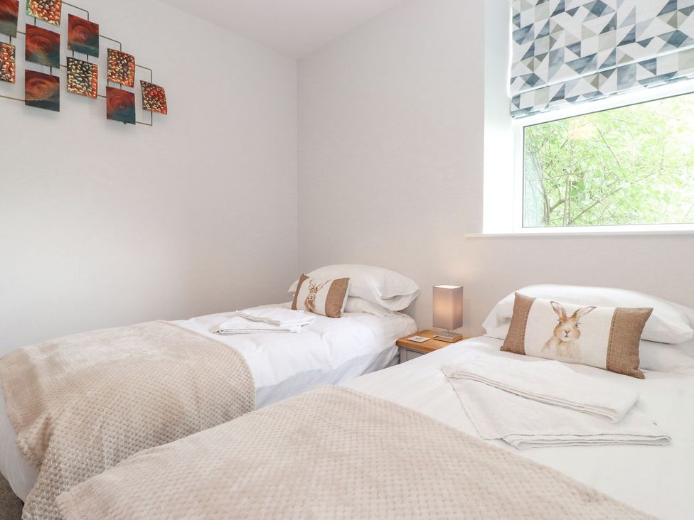A bedroom with two beds and wall art at The Gatehouse