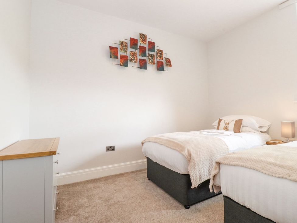 A bedroom with two beds and a dresser at The Gatehouse