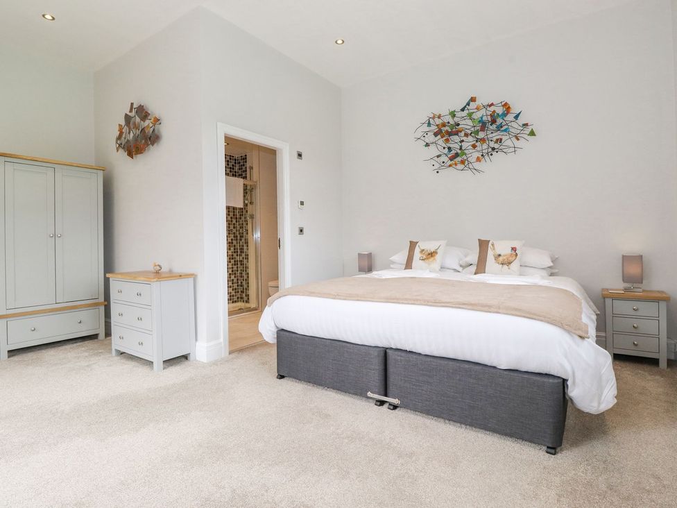A bedroom with a bed, wardrobe, and nightstands at The Gatehouse 