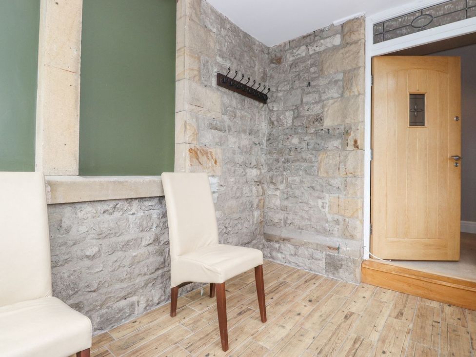 A hallway with stone walls and a door at The Gatehouse