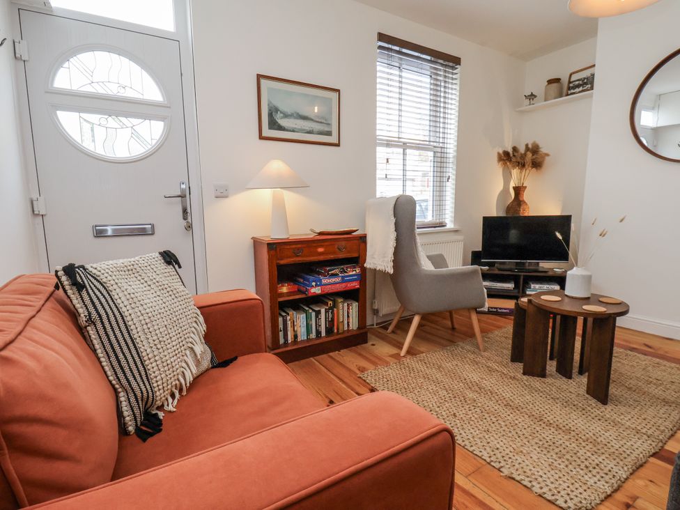 A living room with a sofa and television at Launcher's Cottage in Scarborough