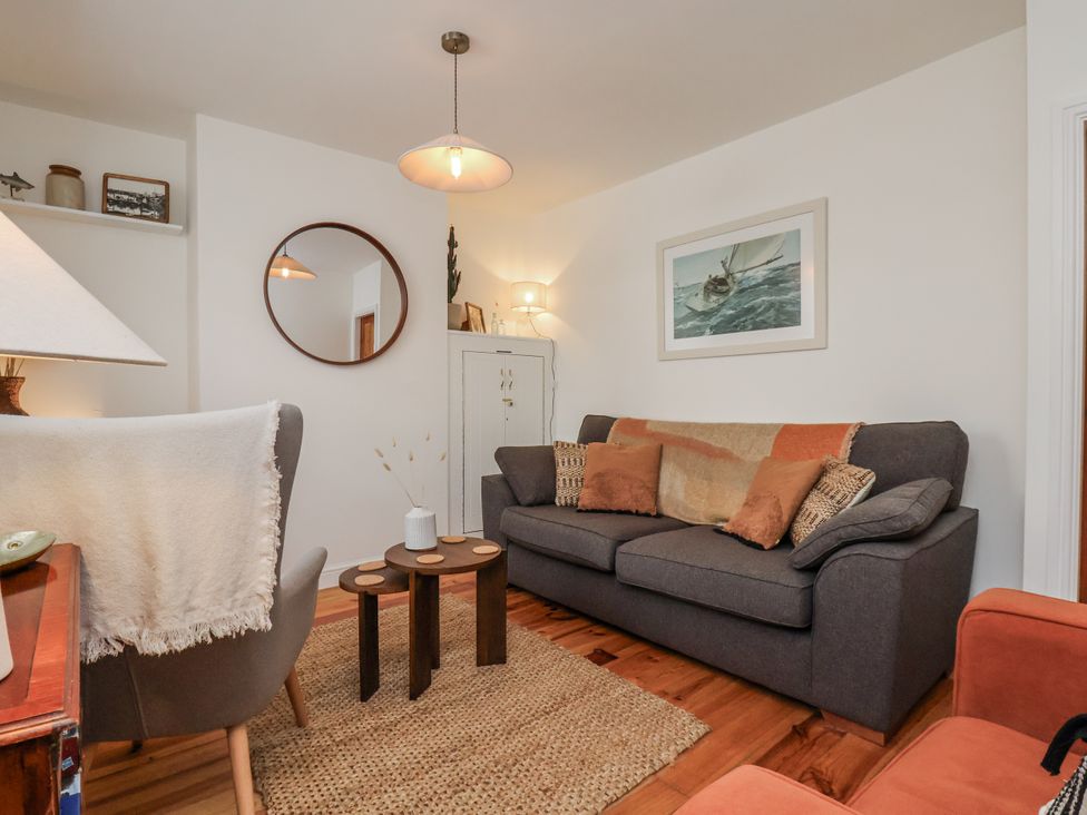 A living room with a sofa, armchair, and coffee table at Launcher's Cottage in Scarborough