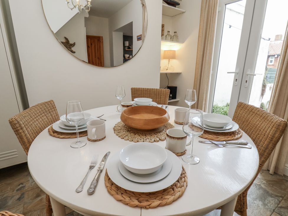 A dining table set with plates and glasses at Launcher's Cottage in Scarborough