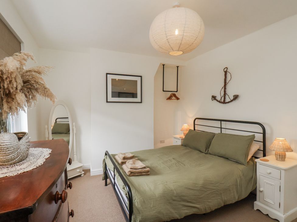 A bedroom with a bed and bedside tables at Launcher's Cottage in Scarborough
