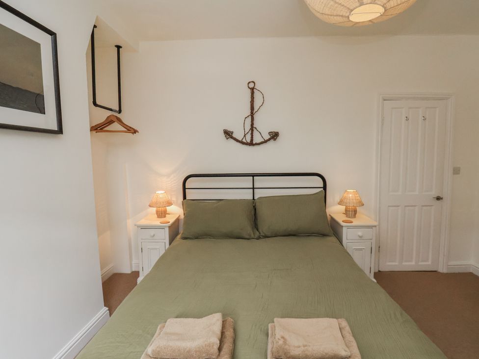 A bedroom with a bed and bedside tables at Launcher's Cottage in Scarborough