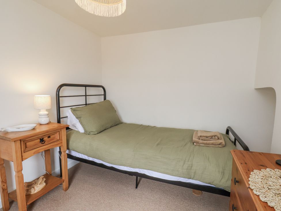 A bedroom with a bed and side table at Launcher's Cottage Scarborough
