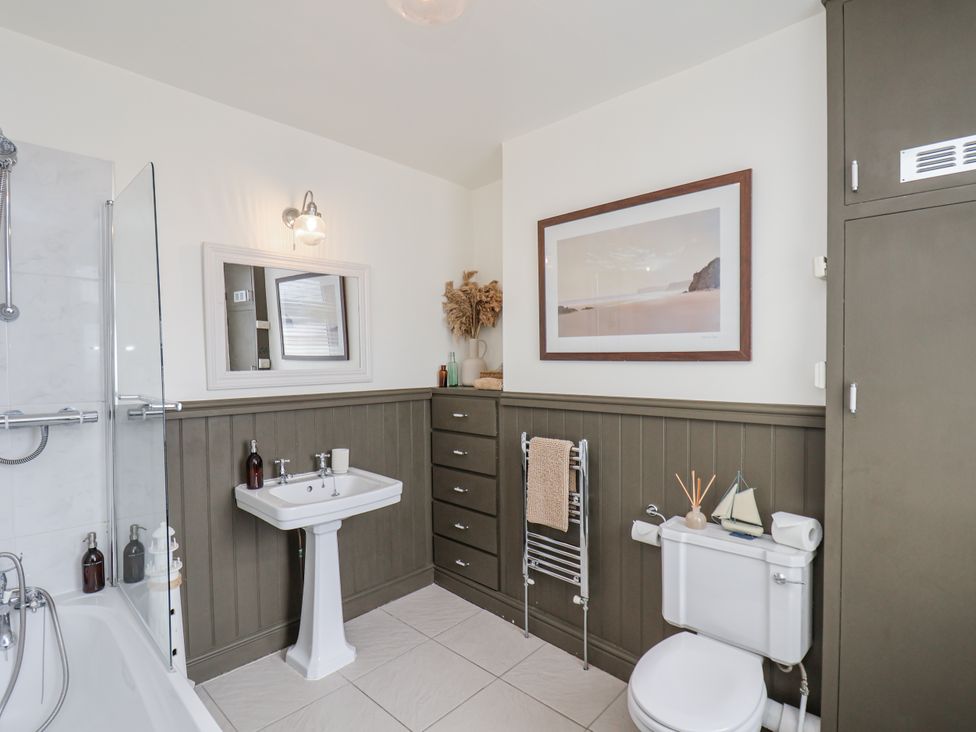 A bathroom with a bathtub and sink at Launcher's Cottage in Scarborough