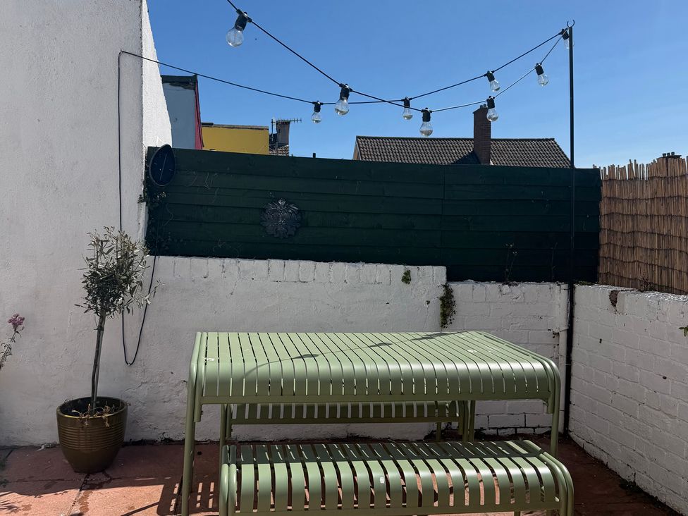 An outdoor seating area with a green table and plant at Launcher's Cottage in Scarborough