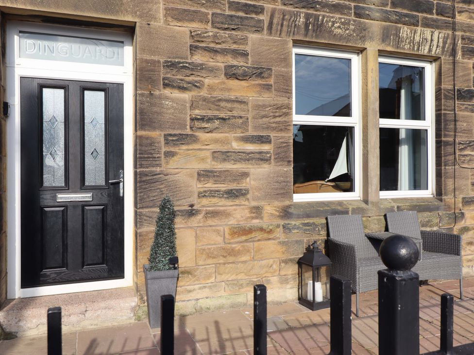 A front entrance with a door and seating area at Dinguardi in Seahouses