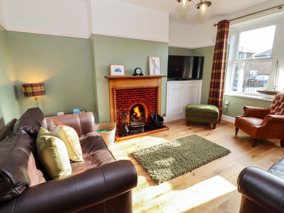 A living room with a fireplace and a television at Dinguardi in Seahouses