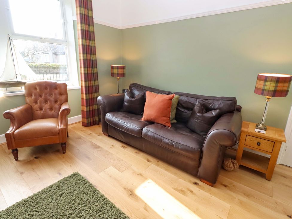 A living room with a sofa and chair at Dinguardi in Seahouses