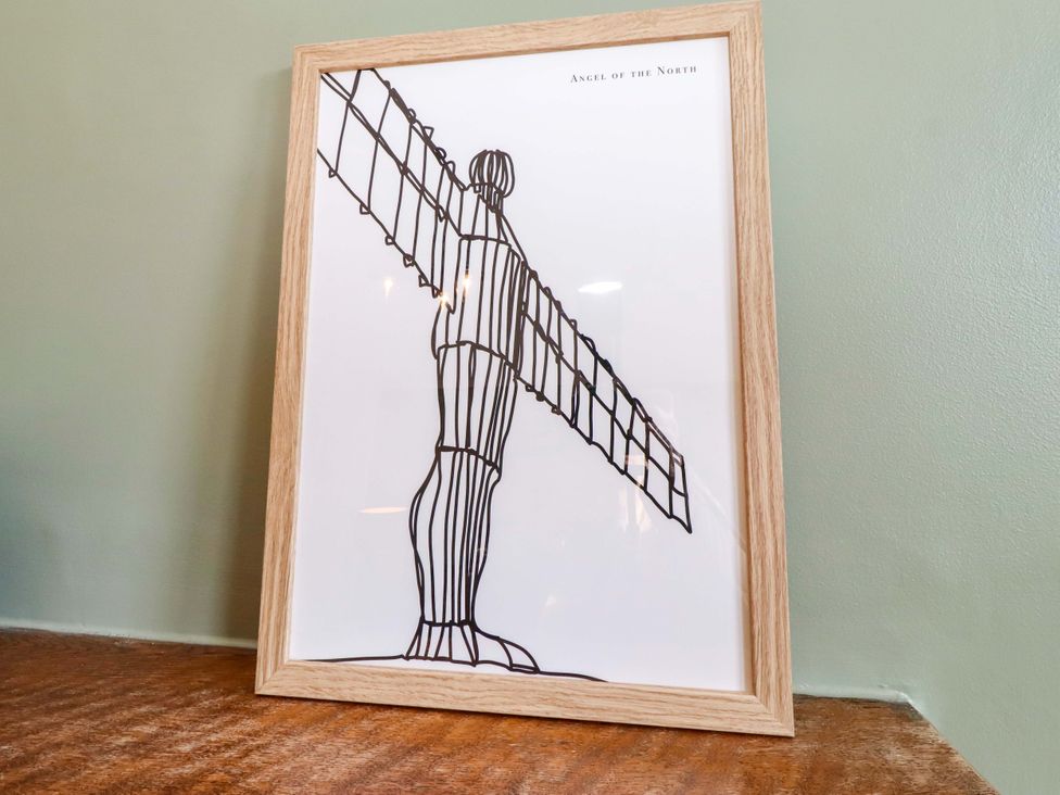 A framed art piece of the Angel of the North at Dinguardi in Seahouses