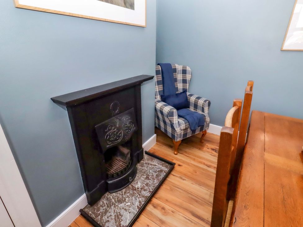 A dining room with a fireplace and an armchair at Dinguardi in Seahouses