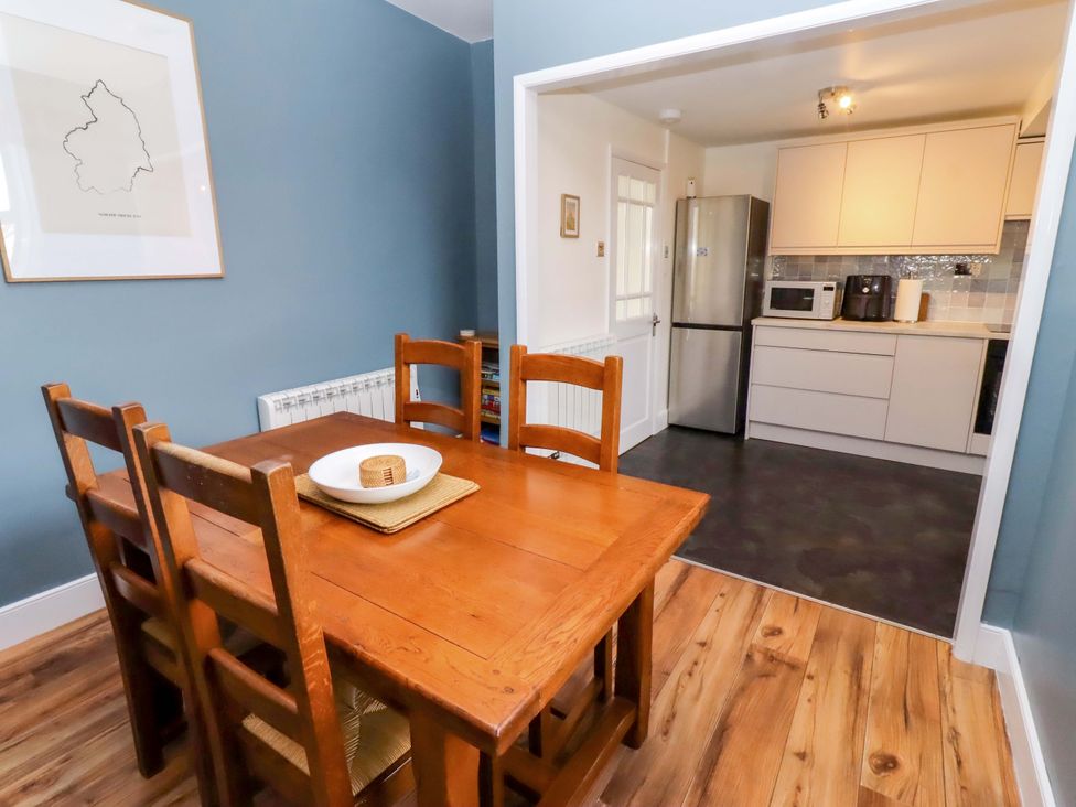 A dining room with a table and chairs adjoining a kitchen at Dinguardi in Seahouses