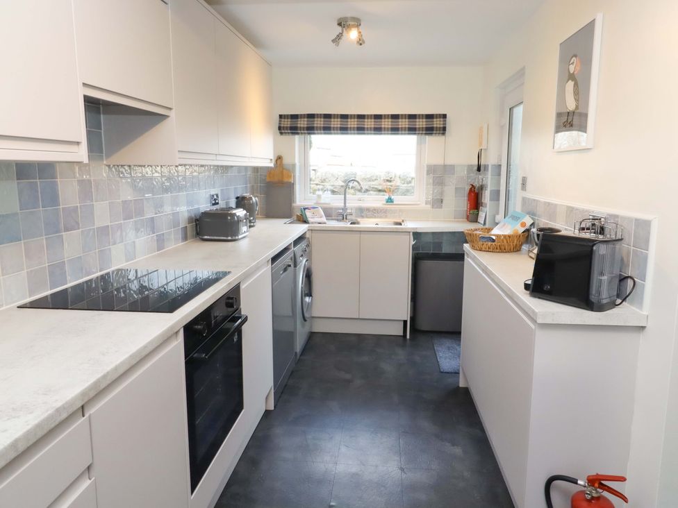 A kitchen with cabinets and appliances at Dinguardi in Seahouses