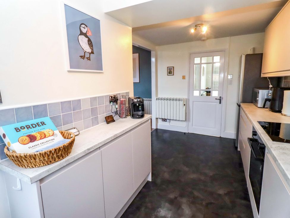 A kitchen with cabinets and appliances at Dinguardi in Seahouses