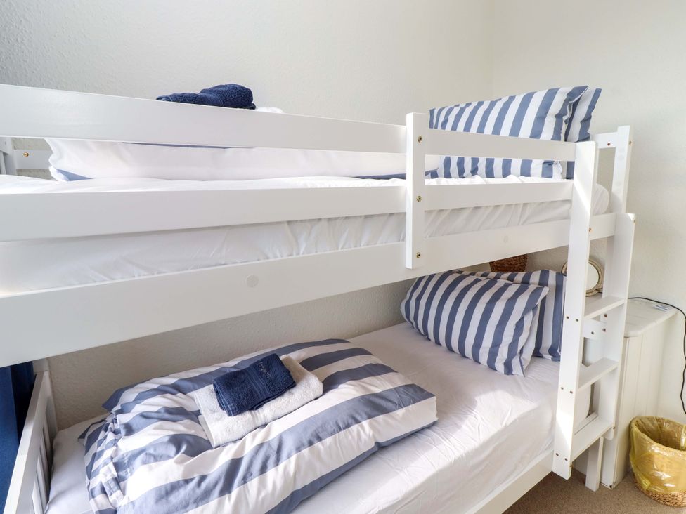 A bunk bed with striped bedding in a bedroom at Dinguardi in Seahouses