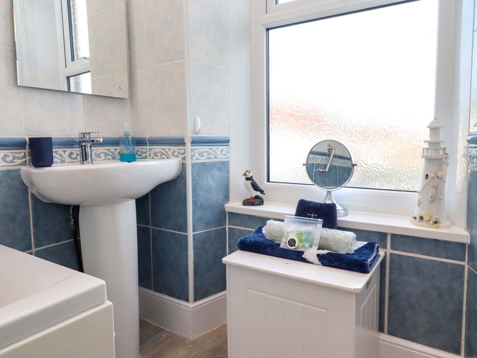 A bathroom with a sink and mirror at Dinguardi in Seahouses